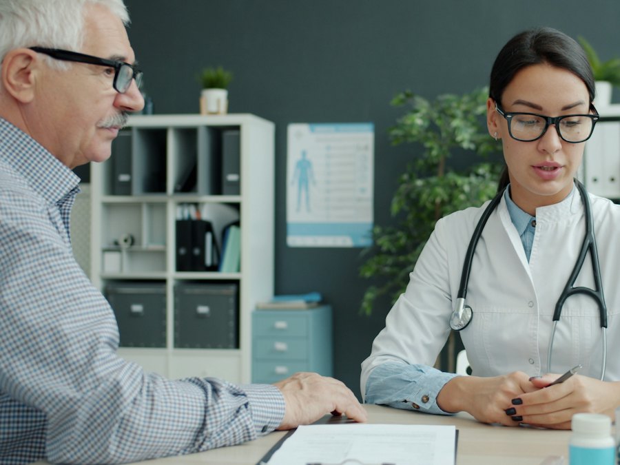 Senior man reviewing coverage with a doctor